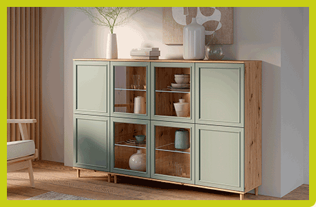 Highboard in einem Wohnraum mit Korpus in Holzoptik und salbeigrünen Fronten im Landhausstil - 4 Vitrinenfächer mit Glas und Sicht in die Fächer - Grüner Rahmen umschließt das Bild