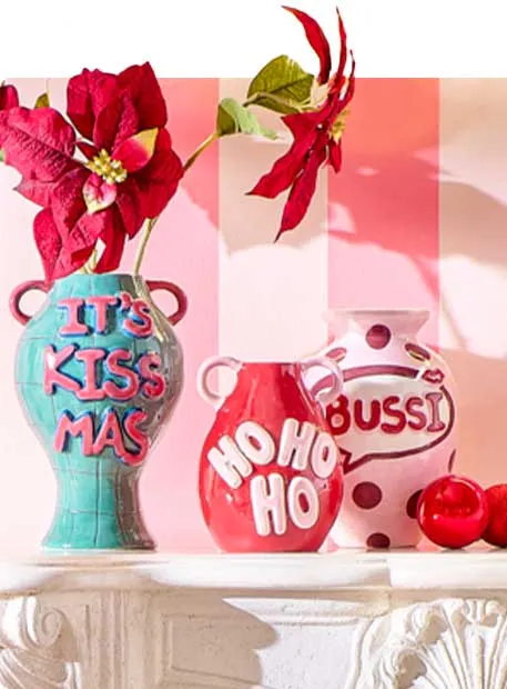 drei bunte Vasen: grüne Vase mit pinker Schrift "Its Kissmas", rote Vase mit rosa Schrift "Ho Ho Ho", rosa Vase mit roter Schrift "Bussi"