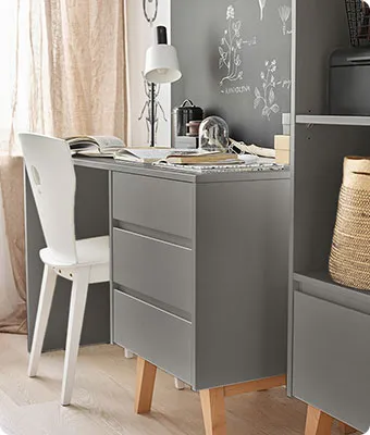 grauer Schreibtisch und Regal mit weißem Schreibtischstuhl in einem Kinderzimmer