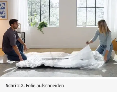 Schritt 2: Folie aufschneiden. Mann und Frau schneiden Folie auf