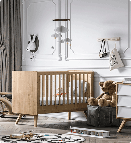 Babyzimmer mit Babybett. Dekoriert mit Teppich, Sitzkissen, Teddybär.