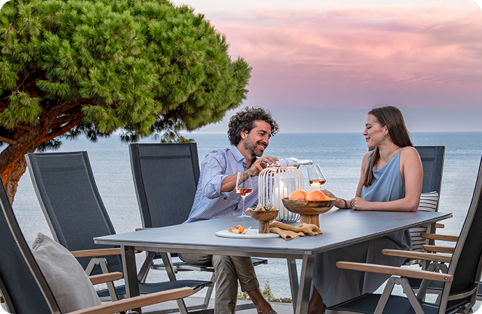 Gartentisch aus Keramik und Edelstahl sowie 5 Gartentstühle aus Edelstahl und Textilgewebe, Paar, am Meer
