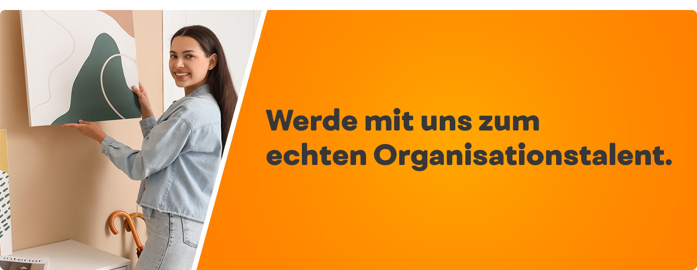 Auszubildende hängt ein Bild an die Wand. Text Werde mit uns zum echten Detailperfektionist.