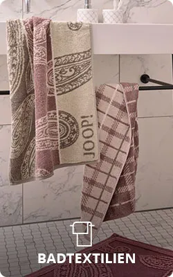 Badtextilien. Weißer Waschtisch mit rosa Handtuch im Karodesign und JOOP! Schriftzug sowie beiges Handtuch mit Paisley-Muster