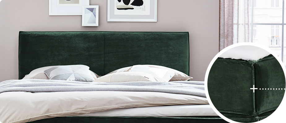 Grünes Boxspringbett mit beiger Bettwäsche in einem Schlafzimmer - Detail-Ansicht von der grünen Matratzenecke mit Keder
