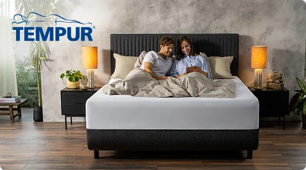 Mann und Frau sitzen auf einem Bett, Logo Tempur