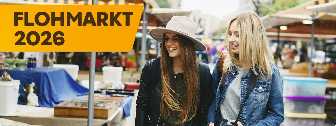 2 Frauen, die über einen Flohmarkt laufen und sich die Stände dort anschauen