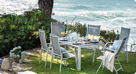 Garten-Dininggruppe aus Tisch und 6 Stühlen im Garten, Meer im Hintergrund