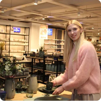 Frau im Villeroy & Boch Studio bei Möbel Kraft hält Geschirrset in der Hand