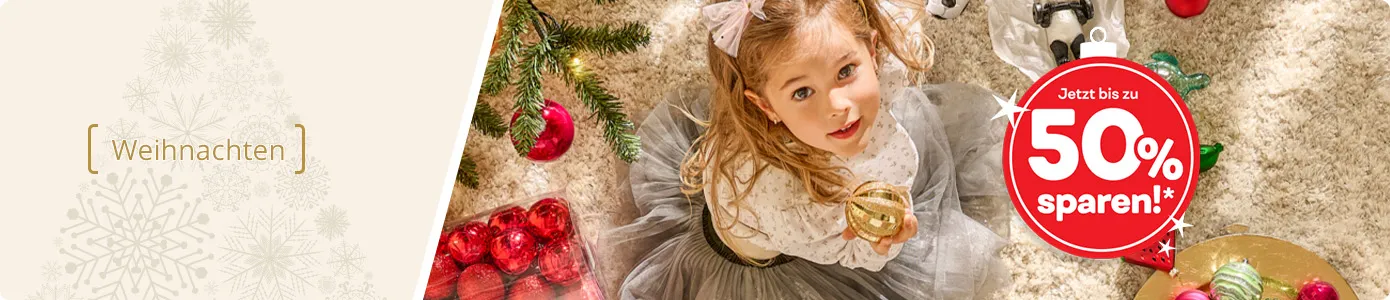 Weihnachten. Mädchen am Weihnachtsbaum mit Weihnachtsbaumschmuck. Text: Jetzt bis zu 50% sparen!*