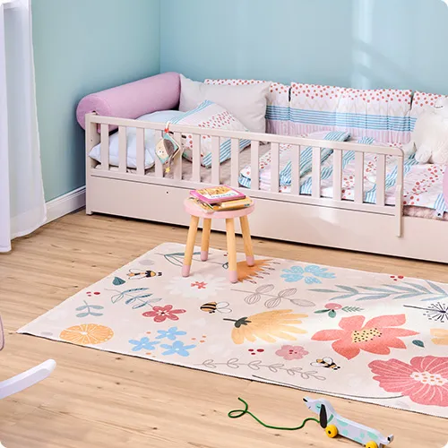 Kinderzimmer mit beigem Bodenbett, Teppich mit Blumenmuster