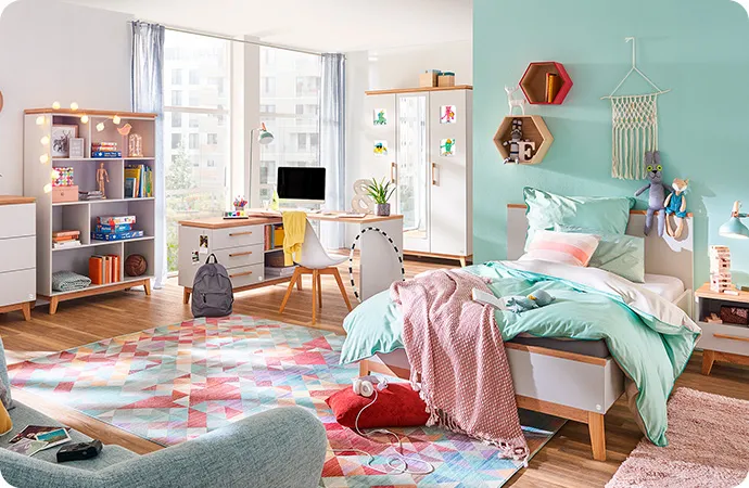 Babyzimmer mit Babybett, Wickelkommode - alle weiß mit Holzakzenten - Kommode mit bunten Bildern - Spielzeug, weitere Möbel