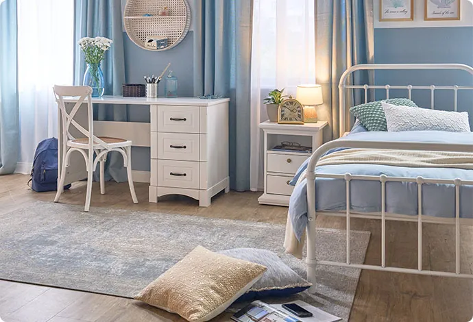 Kinderzimmer mit blauen Wänden und weißen Landhausmöbeln.