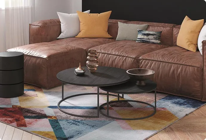 Wohnzimmer mit brauner Ledergarnitur und einem mehrfarbigen Teppich