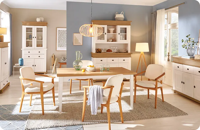 Esszimmer mit einem Esstisch in Eichenoptik und Weiß, 3 weiß-gepolsterte Stühle, Highboard, Vitrine und Buffet in Weiß mit Akzenten in Eichenoptik, Deko.