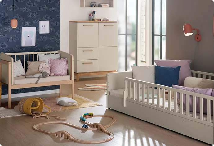 Kinderzimmer mit Kindermöbeln in Creme und Holzoptik, Deko und Spielzeug. 