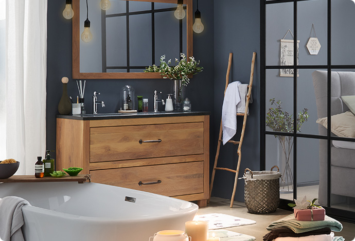 Badezimmer mit Badewanne vor Fenster und dunkelgrauer Doppelwaschtisch, Waschtischunterschrank aus Holz, Spiegel aus Holz