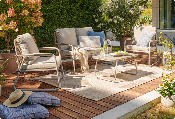 Terrasse mit beigen Metall-Gartenmöbeln, bestehend aus 2 Sesseln, Sofa und Tisch 