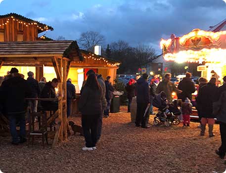 Möbel Kraft Weihnachtsmarkt auf dem Gelände mit beleuchteten Ständen und Karussell