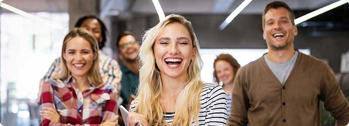 Lachende Männer und Frauen in einem Büro