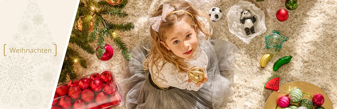 Weihnachten. Mädchen am Weihnachtsbaum mit Weihnachtsbaumschmuck. Text: Jetzt bis zu 70% sparen!*
